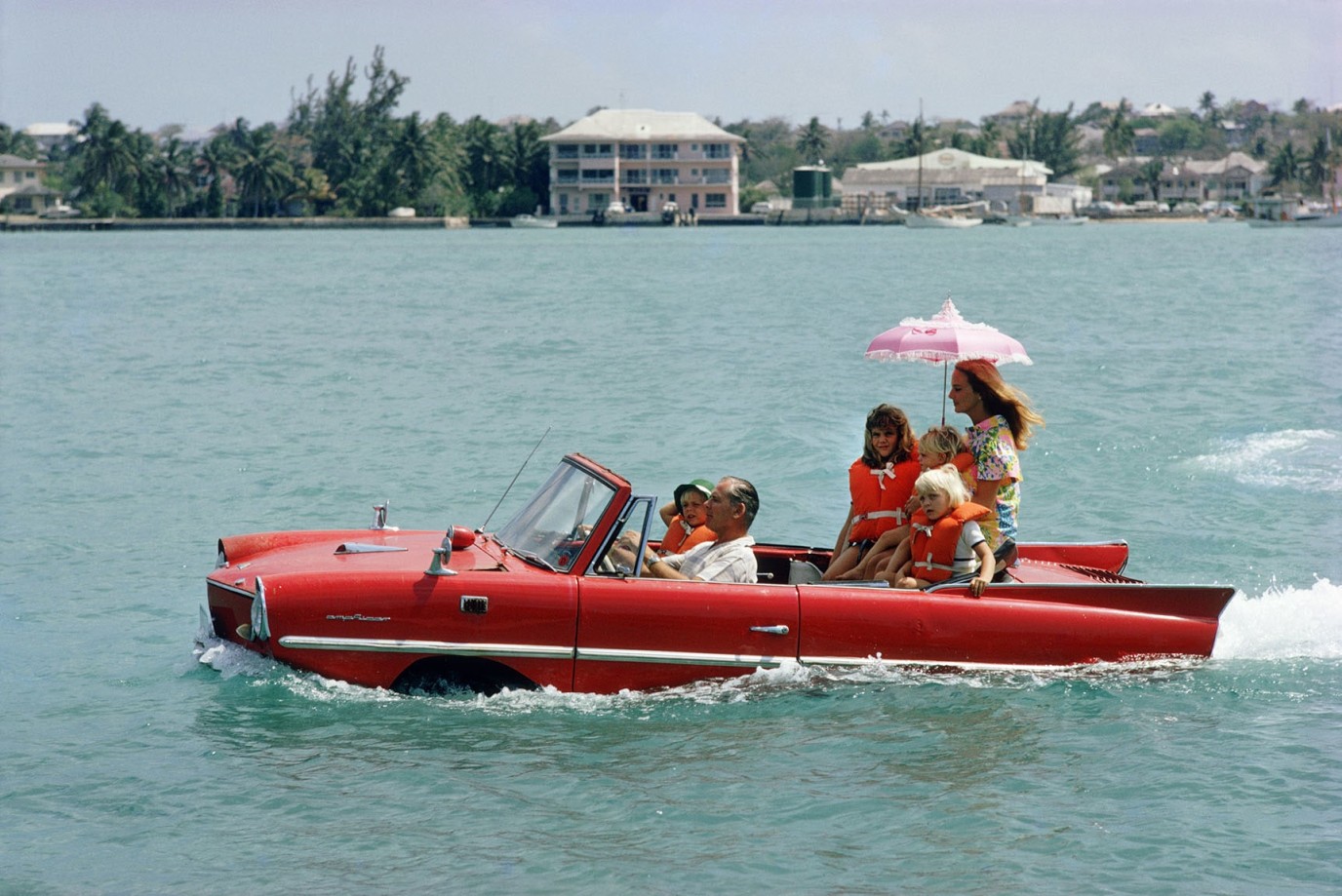 Slim Aarons, Sea Drive, 1967: Film Producer Kevin McClory with wife Bobo Segrist and Family in the “Amphicar” Across the Harbour in Nassau