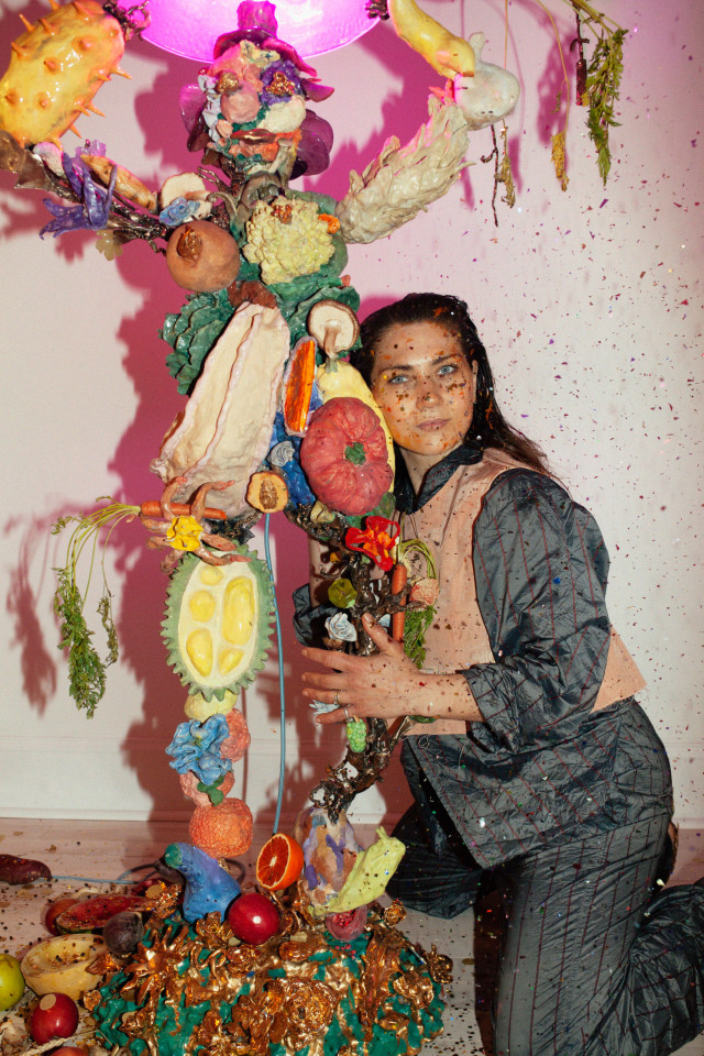 Image of Katie Stout posing with her lamp Janet from 2021 amid glitter