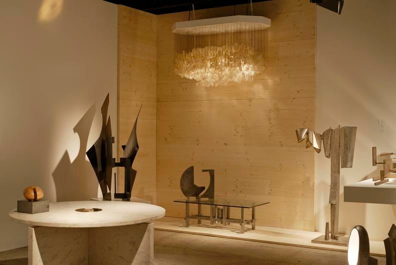 Magen H Gallery's booth at Design Miami/Basel, install view showing Christophe Gevers' circular center/dining table, Pierre Sz&eacute;kely's marble sculpture, Marino di Teana's &quot;Dialogue Forme Espace Edition&quot; sculpture and sculptural coffee table, a French 1960s Mother of Pearl pendant, and Philolaos Tloupas' sculpture