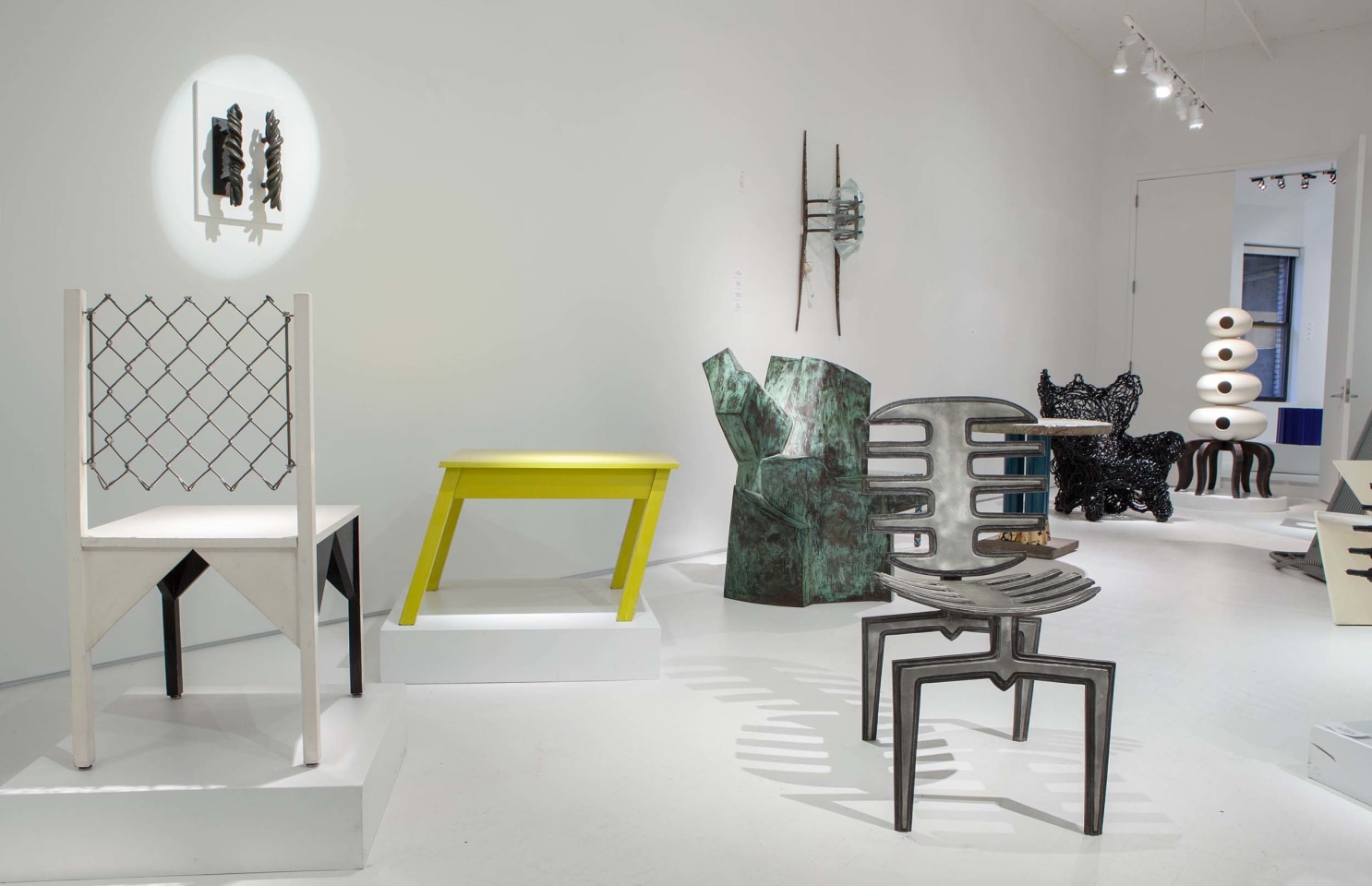 Art et Industrie exhibition installation view: Pieces from left to right are Paul Ludick's Apartheid chair, Michele Oka Doner's door handles, Rafael Barrios' Mesa table, Jim Cole's Dorset Marker, Terence Main's &quot;Amity&quot;, Terence Main's Frond chair 7, and Carmen Spera's &quot;Cafe Rapido&quot; console table, Forrest Myers' Wingback chair and Richard Snyder's Cabinet of the Ancient Squid