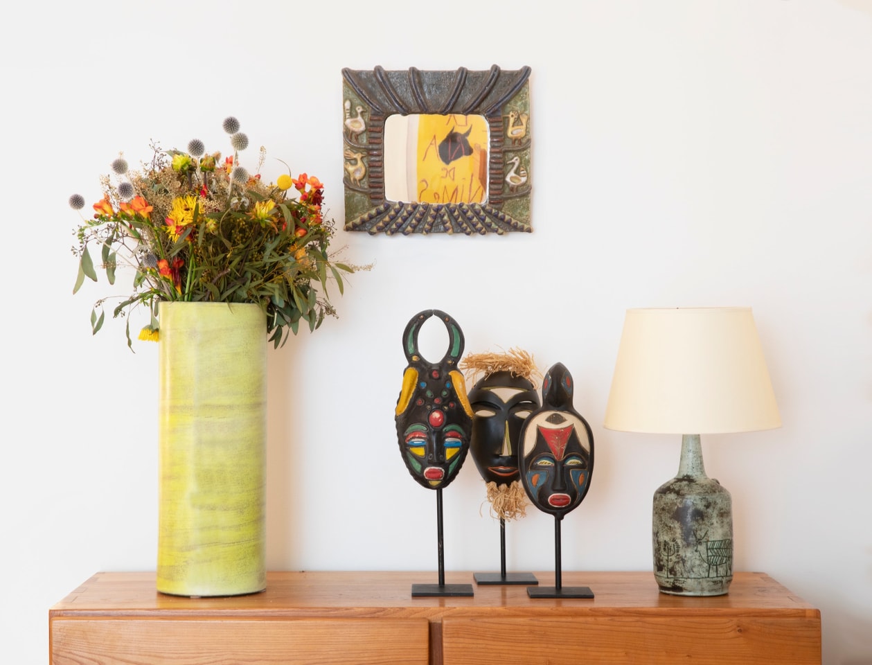 Installation view of exhibition. Piece from left to right are Georges Jouve's ceramic vase, Les Argonautes ceramic mirror, Jaques Sagan ceramic masks and R. Weil's ceramic masks, Jacques Blin's ceramic table lamp on Maison Regain's sideboard