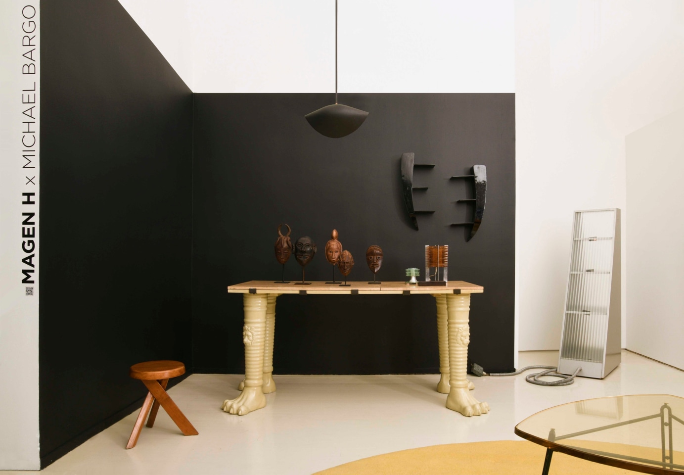 Michael Bargo's room | Pieces from left to right are Pierre Chapo's &quot;S31A&quot; stool (c. 1971), Jean-Charles Moreux's table (c. 1940), Jaque Sagan's mask (c. 1960), New Guinea Oceanian mask (1900s), Jaque Sagan's mask (c. 1960), Gelede's mask from Yoruba People (1900s), Dan Bagle mask (1900s), Serge Mouille's ceiling lamp (c. 1950), Continental bookshelves (c. 1950), Maison Desny's table lamp (1930), French table lamp (c. 1960), and James Hong's Karnak lamp (1979)