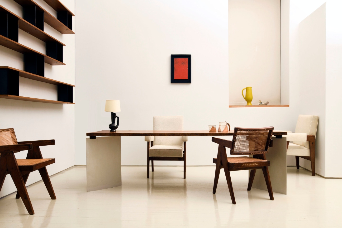 Alyssa Kapito's room | Pieces from left to right are Charlotte Perriand's &quot;Nuage&quot; wall shelving (c. 1950), Pierre Jeanneret's pair of office chairs (c. 1955-56), Jean Paul Barray's table titled &quot;Hommage &agrave; Le Corbusier - Chandigarh&quot; (1965), Unattributed ceramic table lamp (c. 1960), Le Corbusier, Pierre Jeanneret &amp; Jeet Lal Malhotra's &quot;Advocate and Press&quot; armchairs (1954-55), Pierre Sabatier's &quot;M&eacute;tal Rouge&quot; wall sculpture (1980), Gabriele De Vecchi's sculptural coffee and tea set (c. 1980), Pol Chambost's ceramic pitcher (c. 1950), and Jeanine Malarmey's ceramic (c. 1960)