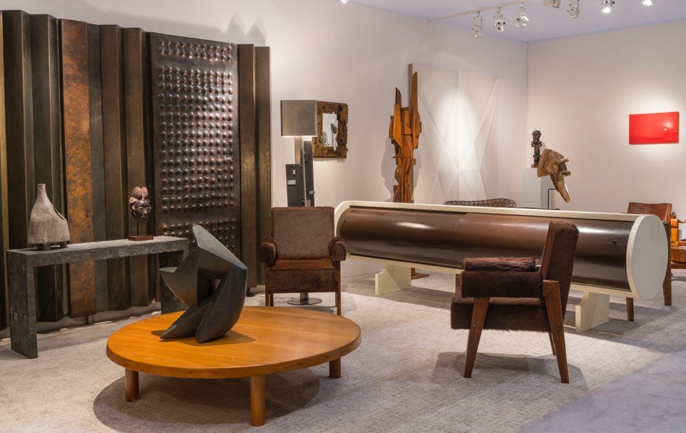 Side installation image of booth, Pierre Sabatier's &quot;Mur Vivant 70&quot; wall sculpture, Pierre Chapo's coffee table, Jonas' &quot;Emprise&quot; sculpture, Pia Manu's console, Pierre Jeanneret's &quot;High Court&quot; armchairs, Jean Louis Chaneac's tubular sideboard