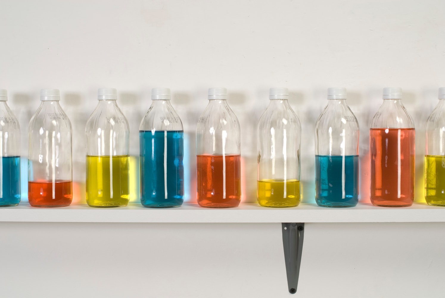 Tony Feher (Chanting One), 2008 Signed on shelf verso 34 glass bottles with screw caps, water, food color and painted wood shelf 8 1/4 x 120 1/2 x 3 1/2 inches 21 x 306.1 x 8.9 cm