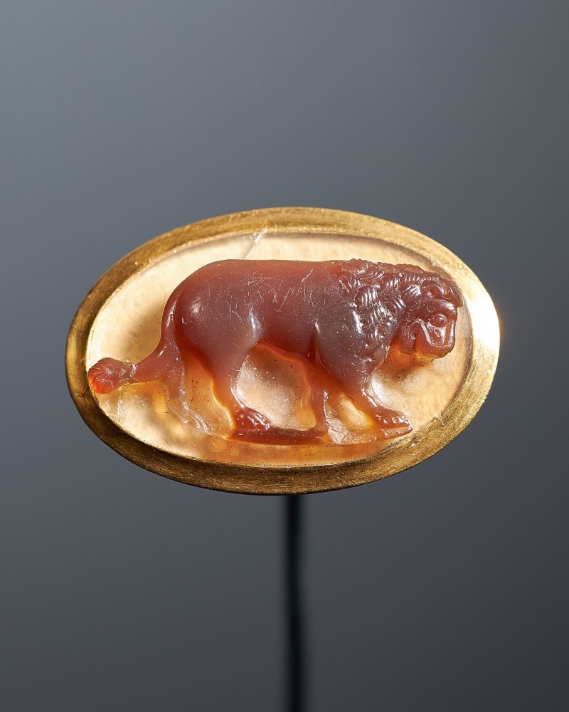 A large cameo of a lion from the court of Frederick II, c. 1230
Southern Italy
Sardonyx cameo in a modern gold ring setting on a white paper backing; a small sardonyx repair to the upper left corner behind the animal&amp;rsquo;s haunches
5/8 x 7/8 inches
(1.7 x 2.3 cm)