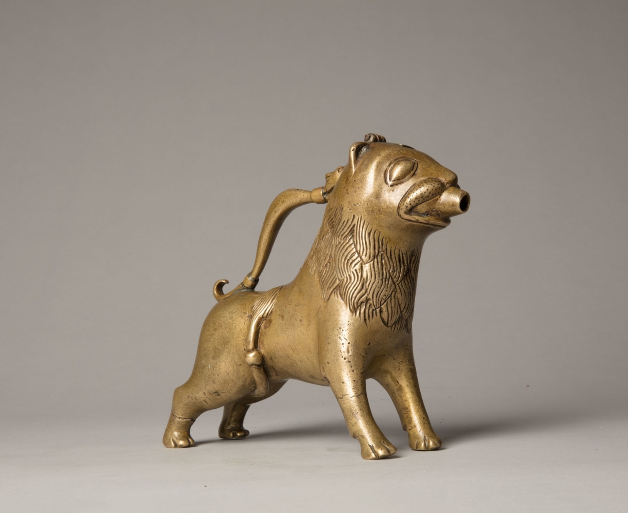 An aquamanile in the form of a lion, Early 13th century
Germany, probably Lower Saxony
cast copper alloy with fine soldered repairs to the handle at its upper and lower connecting points. Hairline fractures to the legs in two places. The hinged lid a modern replacement.
6 3/4 x 9 1/8 x 2 1/8 inches
(17.1 x 22.9 x 5.5 cm)