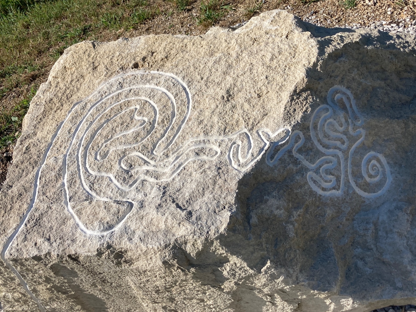 Limestone carving of finger labyrinth at the start of the path of here-ing.