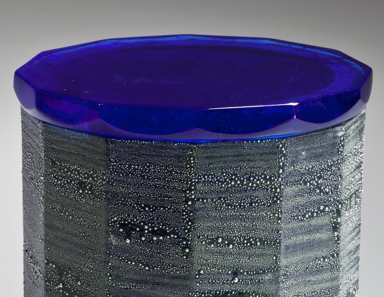 Faceted water jar with cobalt blue glaze, turquoise blue interior, and &amp;quot;silver mist&amp;quot; over-glaze with a cast glass lid

2015

Glazed porcelain and cast glass cover&amp;nbsp;&amp;nbsp; &amp;nbsp;

6 3/4 x 5 5/8 x 5 5/8 in.