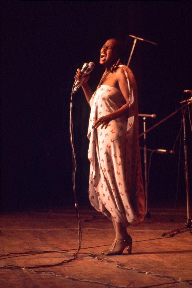 Roy Lewis (b. 1937)
Miriam Makeba Sings at National Theater, 1977
Archival inkjet print on Simply Elegant Gold Fibre paper
Image: 20 x 13 3/4 inches (50.8 x 34.9 cm) Sheet: 22 x 17 inches (55.9 x 43.2 cm)
Framed: 25 3/8 &amp;times; 18 5/8 &amp;times; 1 1/2 inches (64.5 &amp;times; 47.3 &amp;times; 3.8 cm)
Edition of 5, printed 2023