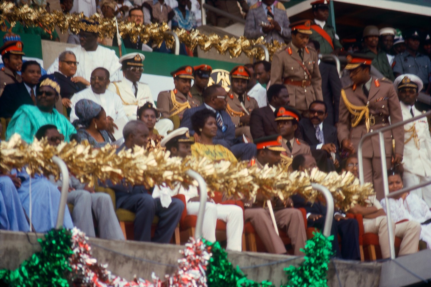 Roy Lewis (b. 1937)
Lt. General Oluse Gun Obasanjo and FESTAC Officials on Viewing Stage, Opening Day, 1977
Archival inkjet print on Simply Elegant Gold Fibre paper
Image: 13 3/4 x 20 inches (34.9 x 50.8 cm) Sheet: 17 x 22 inches (43.2 x 55.9 cm)
Framed: 18 5/8 &amp;times; 25 3/8 &amp;times; 1 1/2 inches (47.3 &amp;times; 64.5 &amp;times; 3.8 cm)
Edition of 5, printed 2023