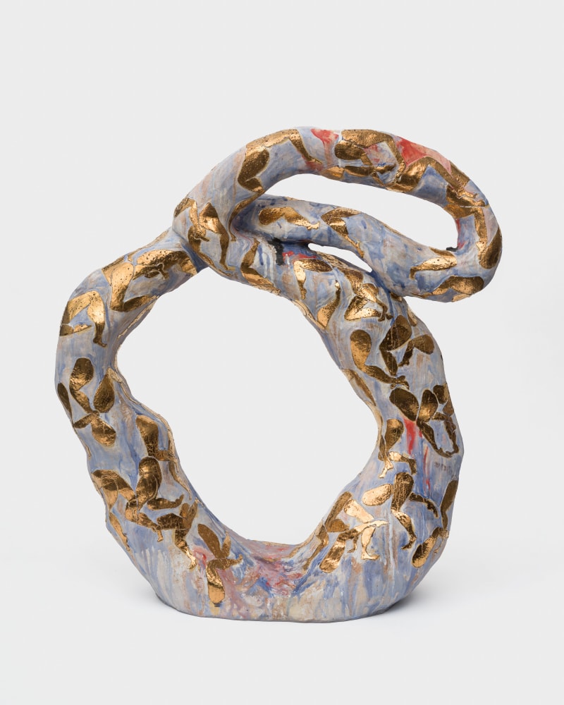 A pale blue ceramic sculpture in a slouched infinity shape with golden legs painted on the surface.