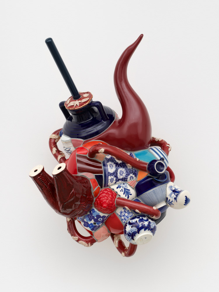 A composite ceramic sculpture made from fragments of burgundy and blue animal figurines, bowls, cups and vases.