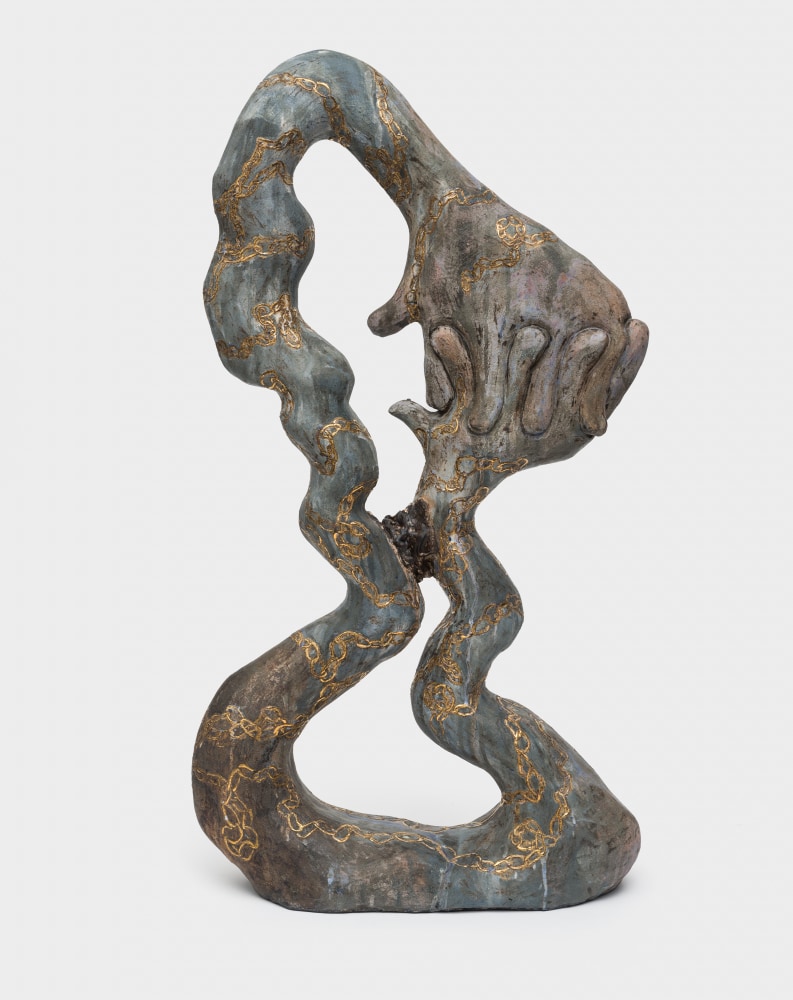 A large ceramic sculpture in a metallic glaze with hands interlocked and a golden chain painted on the surface.