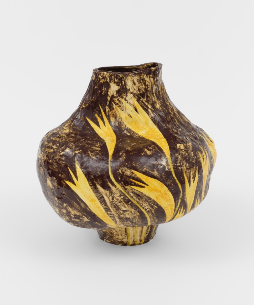 A large round ceramic brown painted vase with yellow flowers.