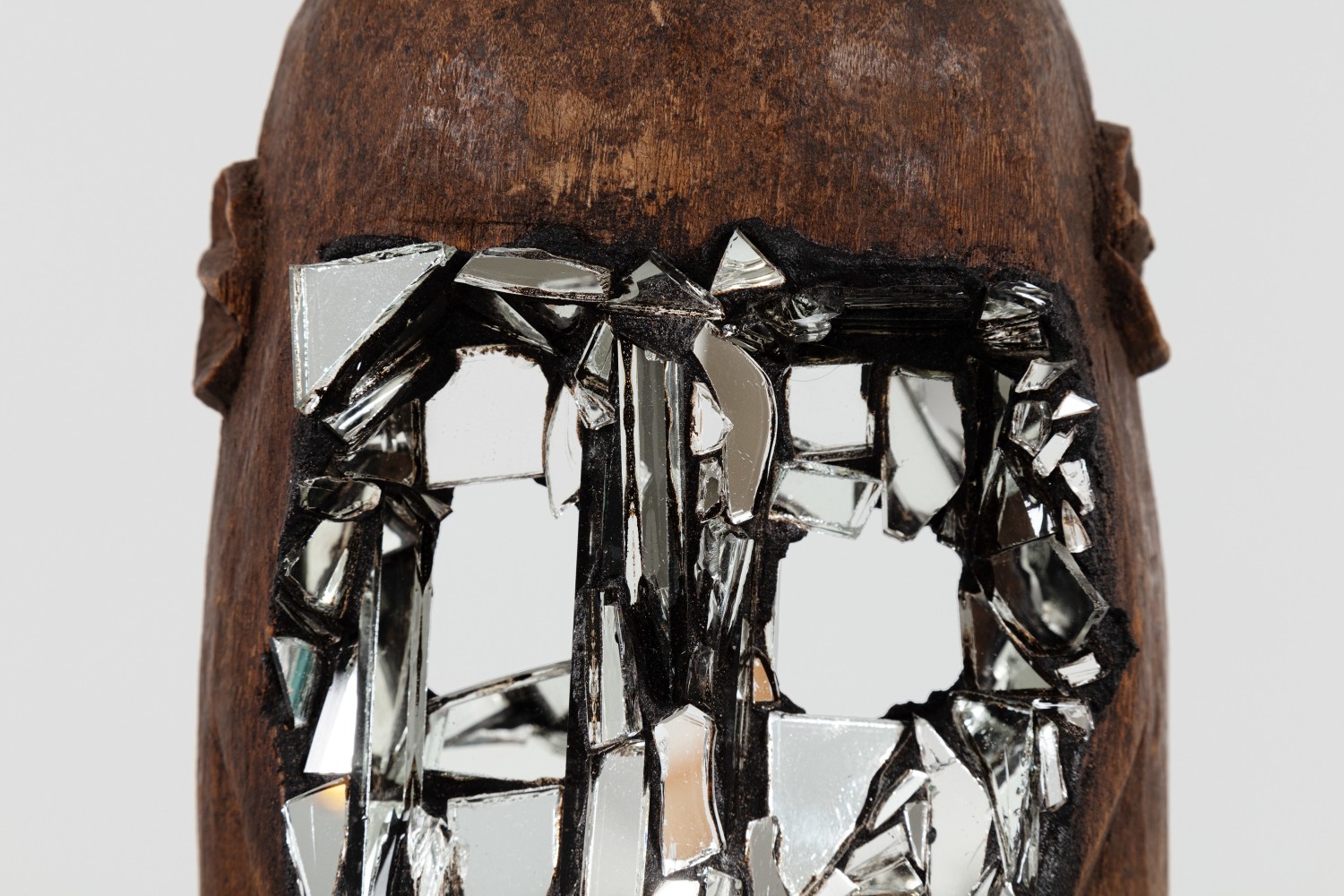 Kader Attia
Mirror Mask&amp;nbsp;(detail)
2020
Wooden mask, mirror fragments, black pigment
Artwork Dimensions:
11 3/4 x 6 5/8 x 5 1/2 inches (30 x 17 x 14 cm)
Overall Dimensions:
70 x 10 x 10 inches (177.8 x 25.4 x 25.4 cm)