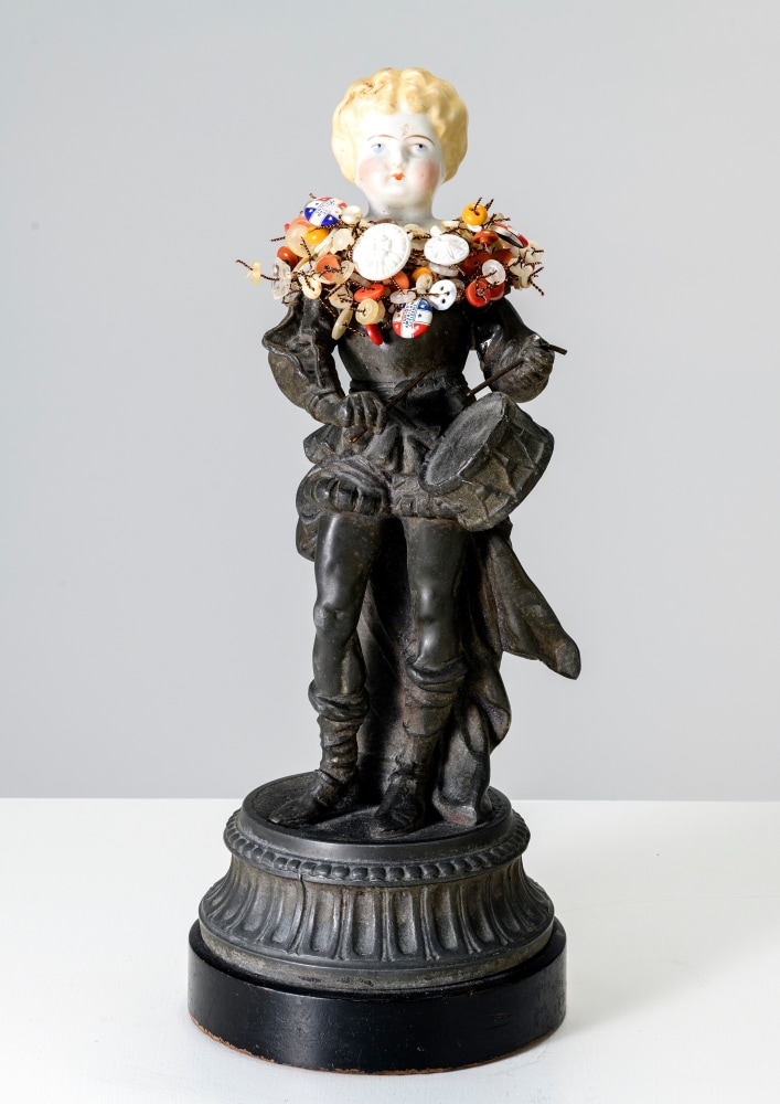 Karin Broker  Drumming Girl, 2022  cast metal, porcelain, buttons, DAR buttons, wire  13 1/2 x 5 1/2 x 5 1/2 inches marble pedestal: 34 1/4 x 8 1/4 x 8 1/4 inches  $12,000