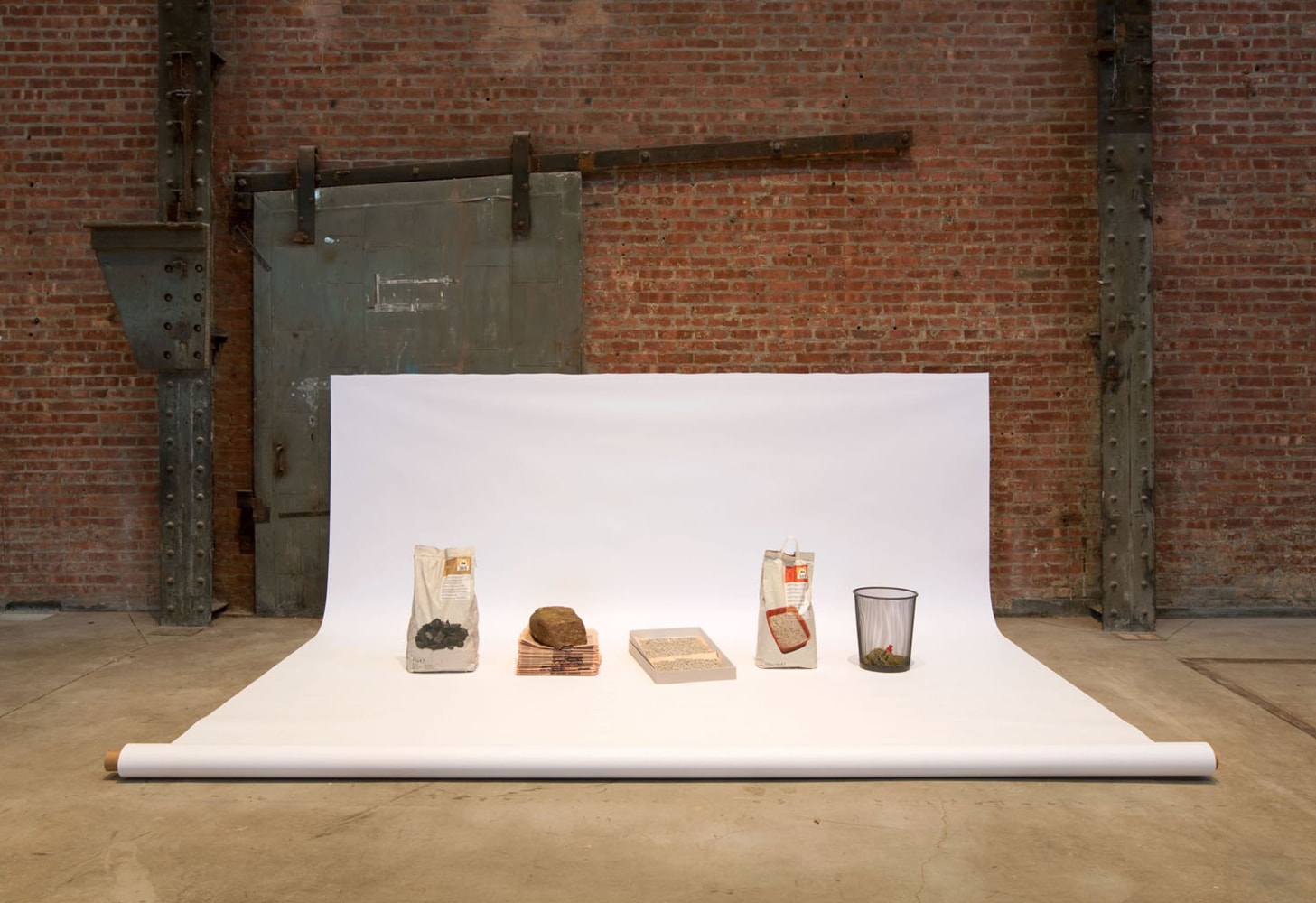 that runs through, 2009
bag of charcoal, stone, stack of financial times; archival box, newspaper, kitty litter, bag of kitty litter; wastebasket, mophead, backdrop paper.
140 x 88 x 54 in.

&amp;nbsp;

&amp;nbsp;