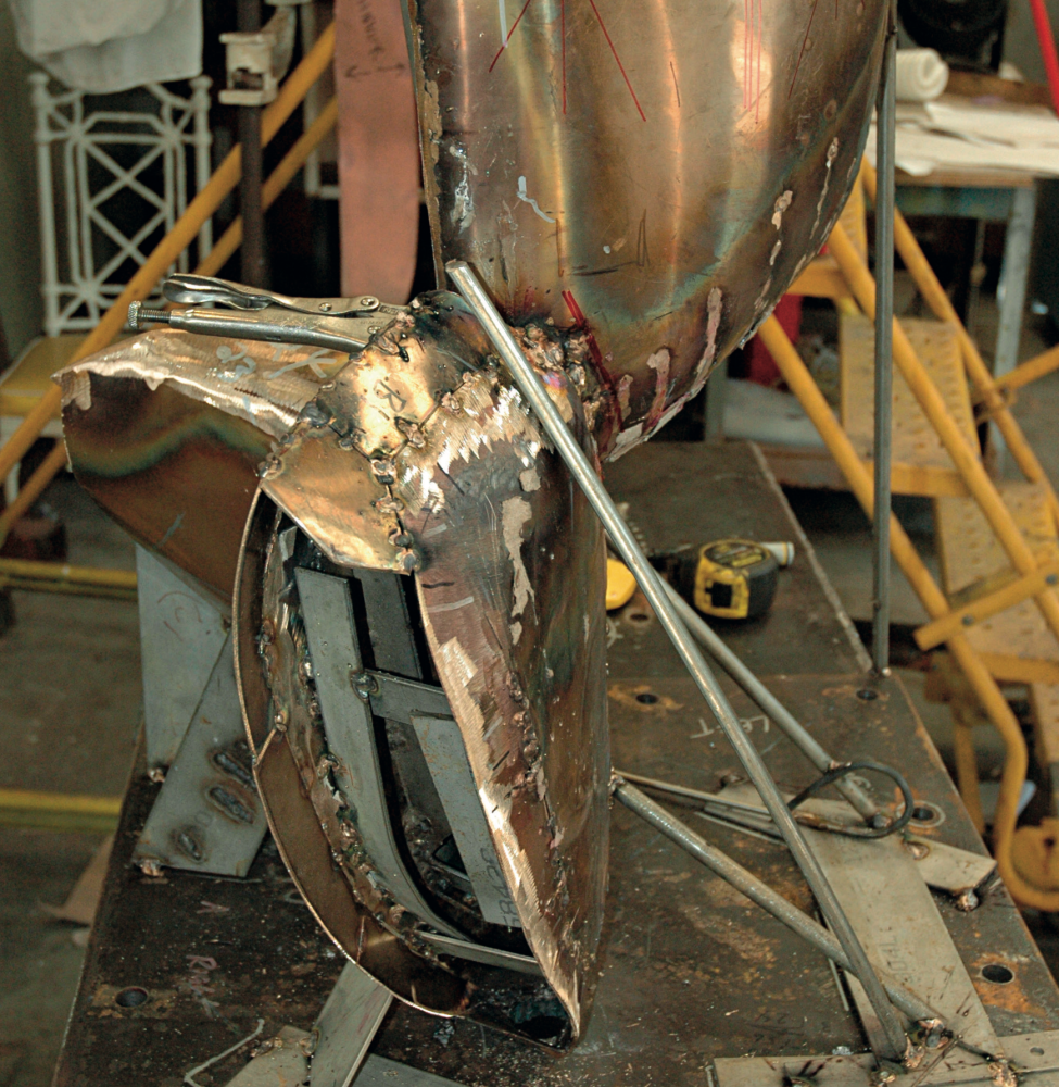 Cutaway view of a sculpture in progress revealing internal structural elements and temporary supports.