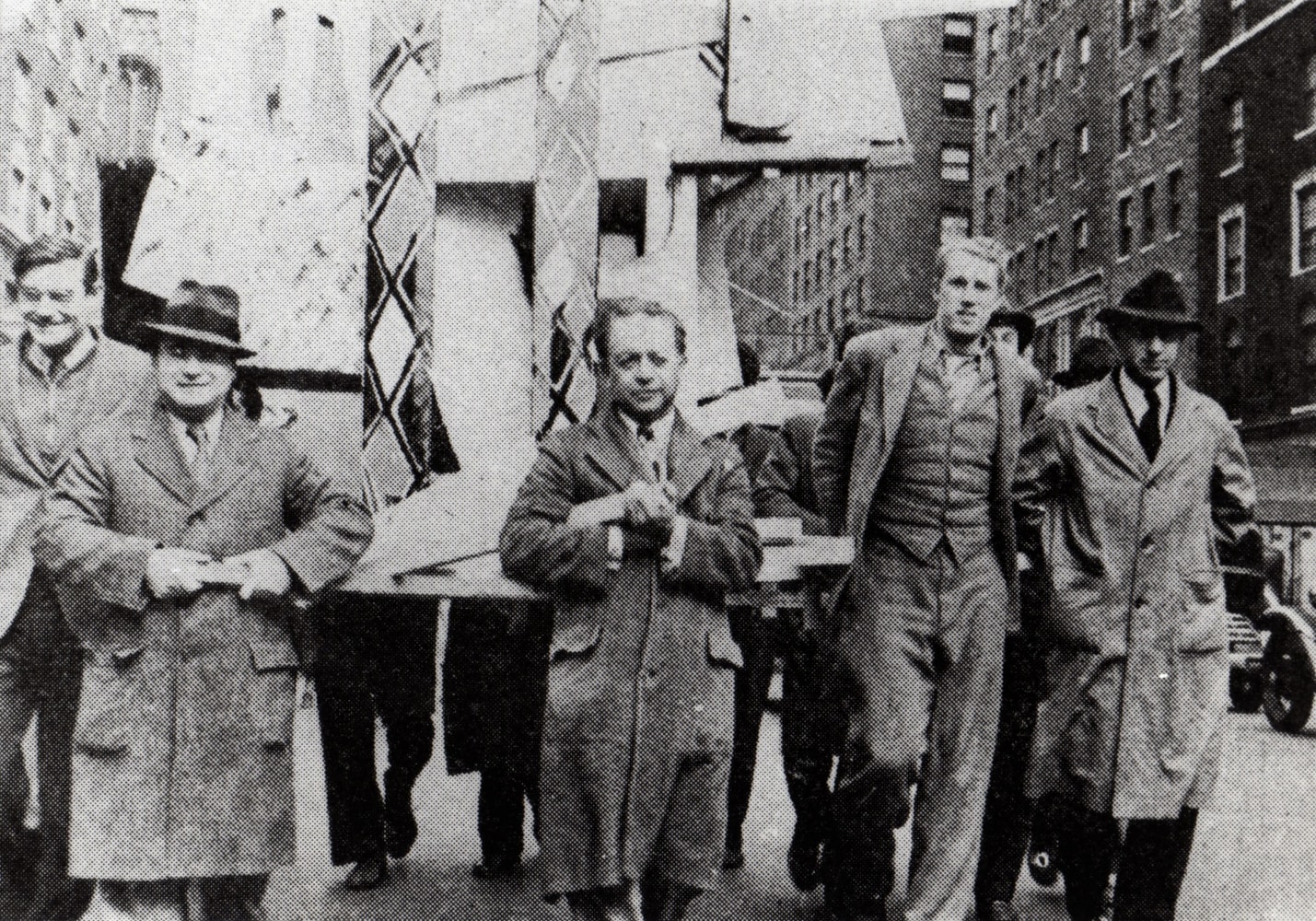 Five men walking down a New York City street holding a float for a parade