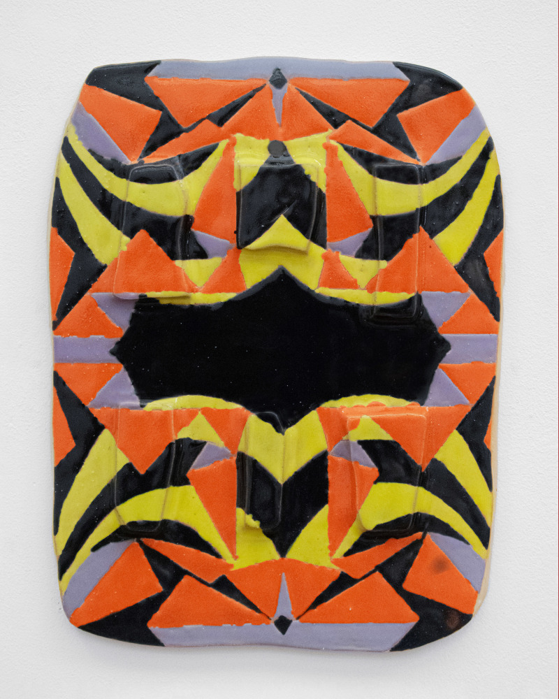 a loosely geometric yellow, black, orange and purple patterned tablet with a surface oscillating between canvas and clay.
