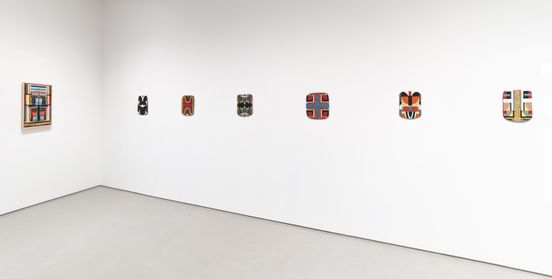 installation view of Kevin Umaña's ceramic tablets and hybrid paintings
