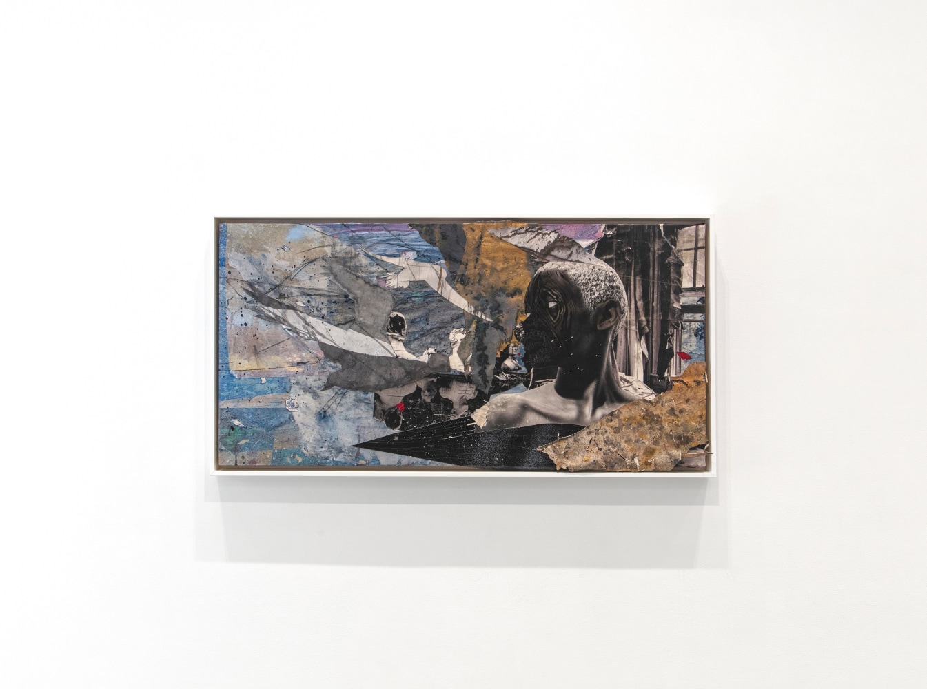 an installation view of a mixed media collage featuring a figure looking to the left.