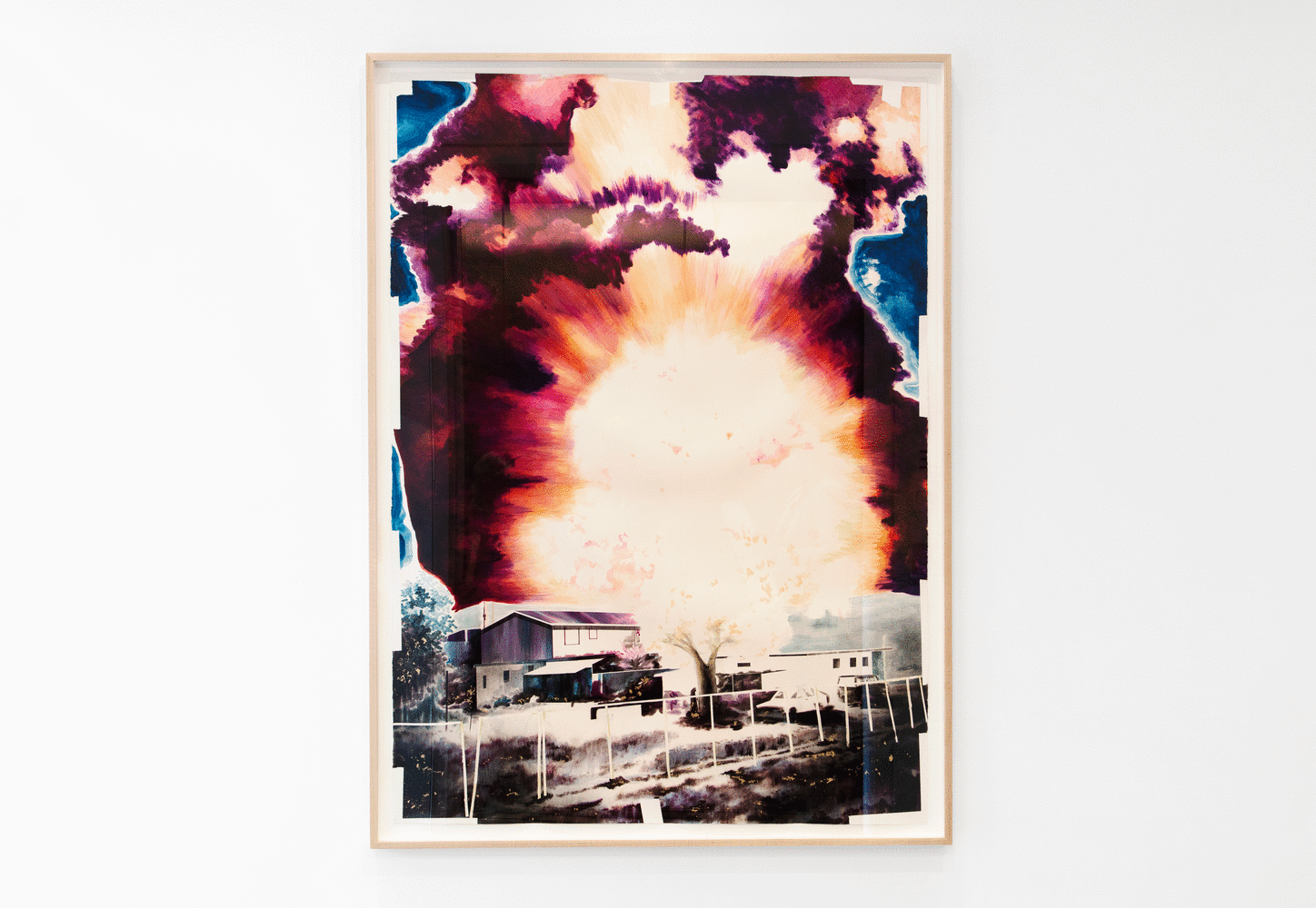 A large colorful artwork depicting an explosion with a house in front of it hangs on a white gallery wall
