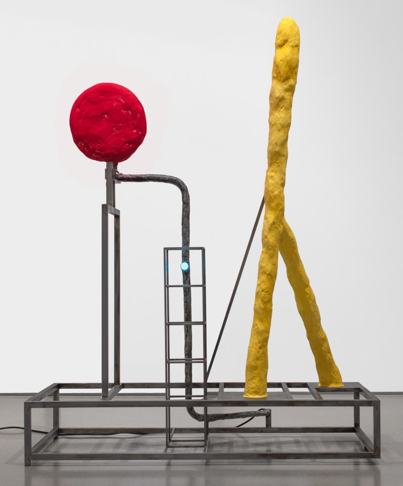 large lamp sculpture with a rectangular metal base and two colorful shapes including a red disc and a yellow inverted y-shape