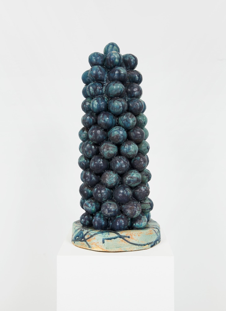 ceramic sculpture glazed in dark blue and turquoise composed of numerous clay balls to form a knobbly, cylindrical structure