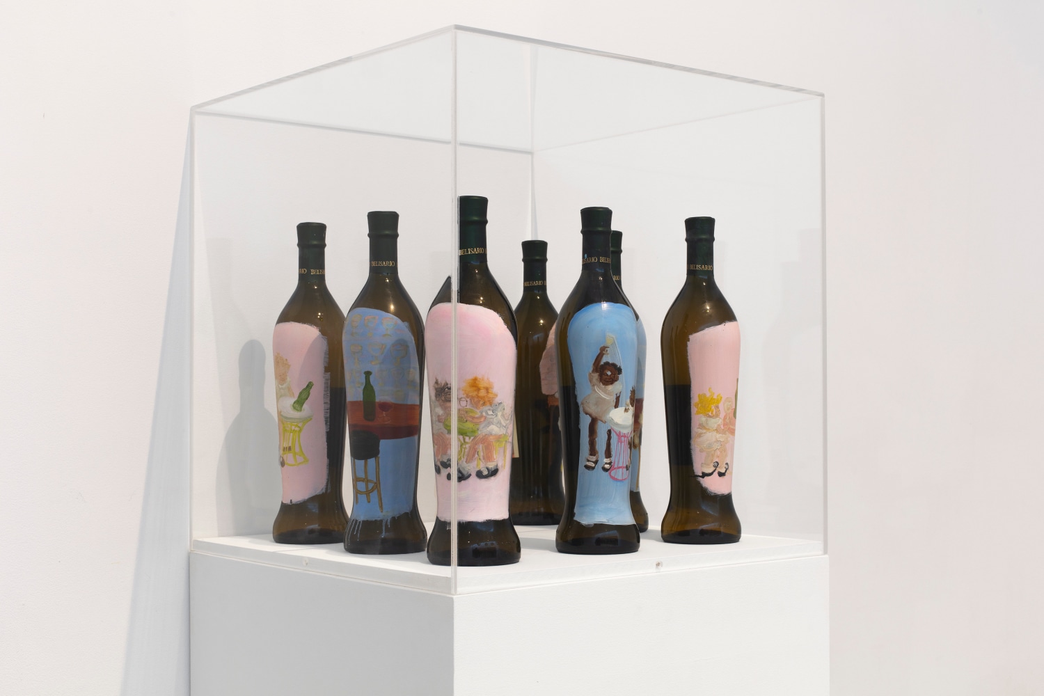 a plexiglass vitrine filled with a series of seven bottles of Verdicchio painted with images of girls