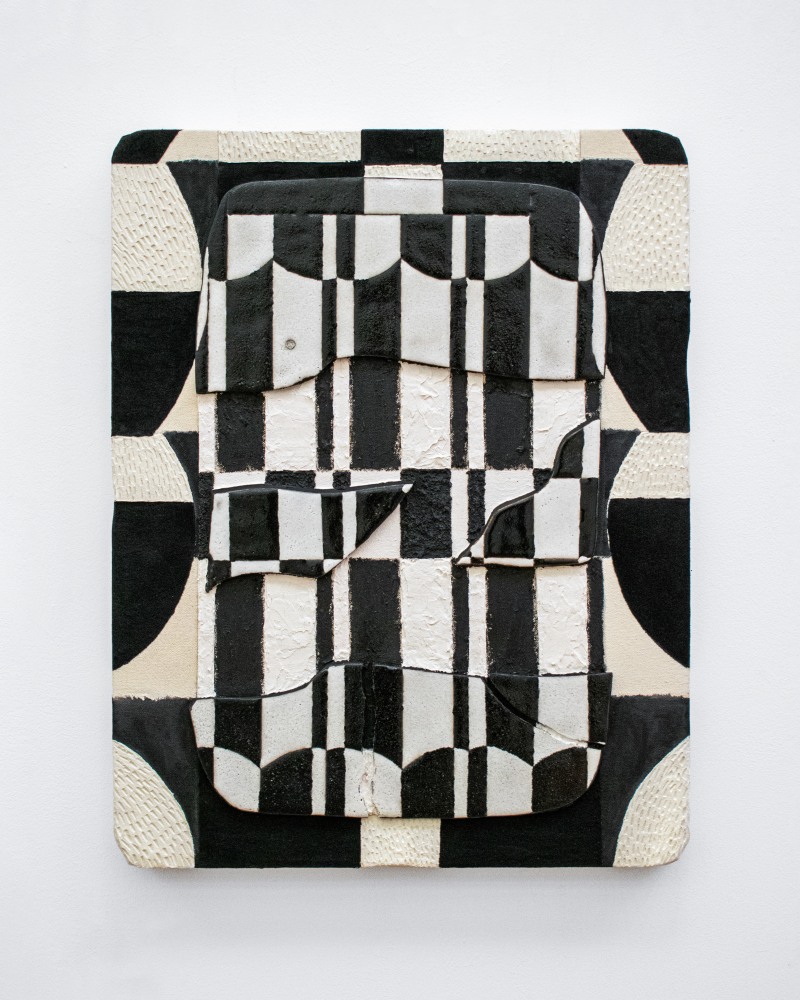 A black and white geometric tablet featuring clay details in alternating shapes and glazes in alternating sheens.