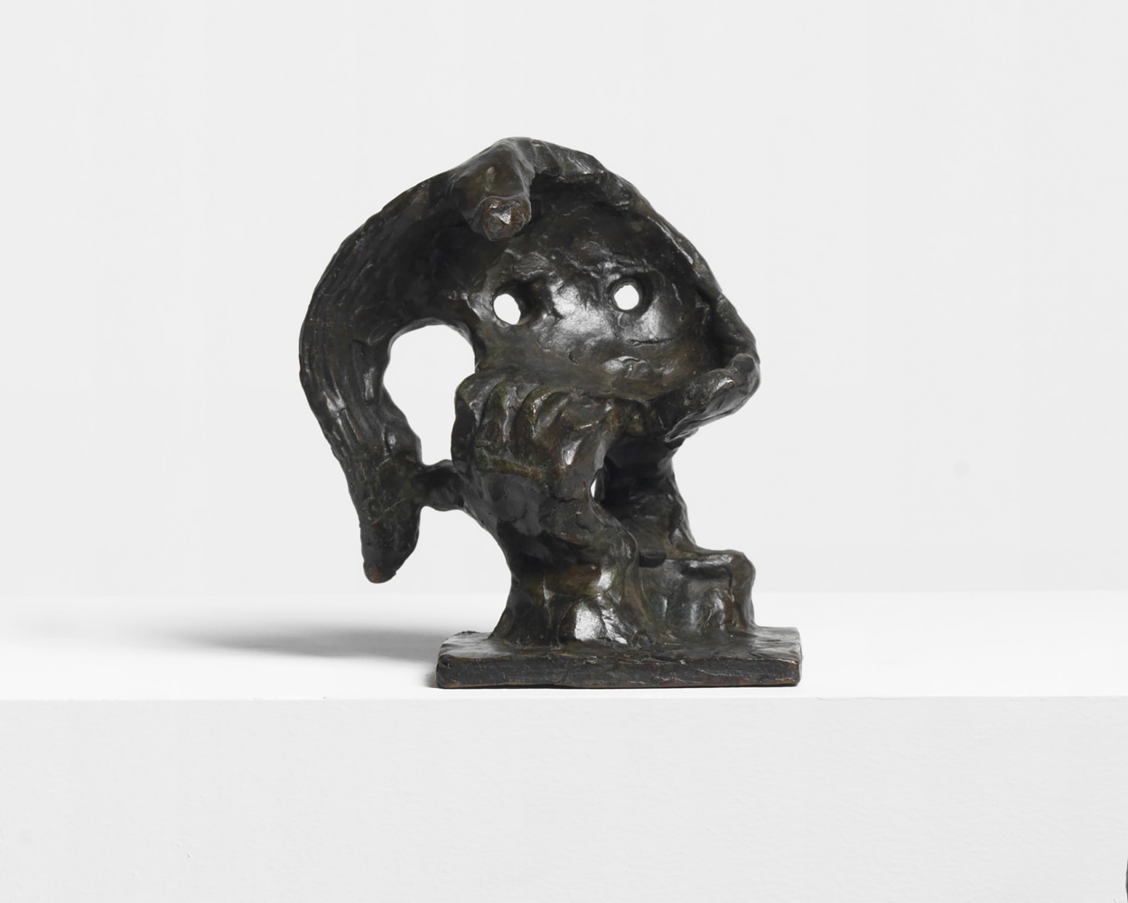Abstract bronze sculpture depicting the head of a woman, hair, and hand.