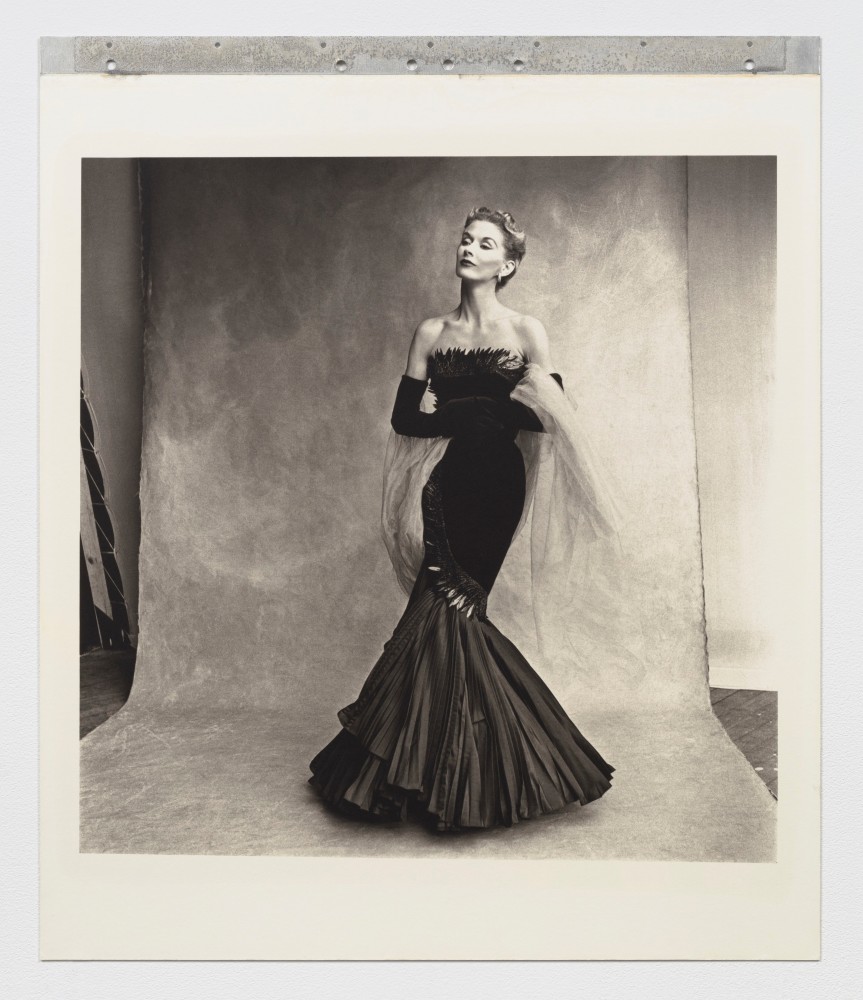 Black and white photographic portrait of a woman in a black mermaid style dress.