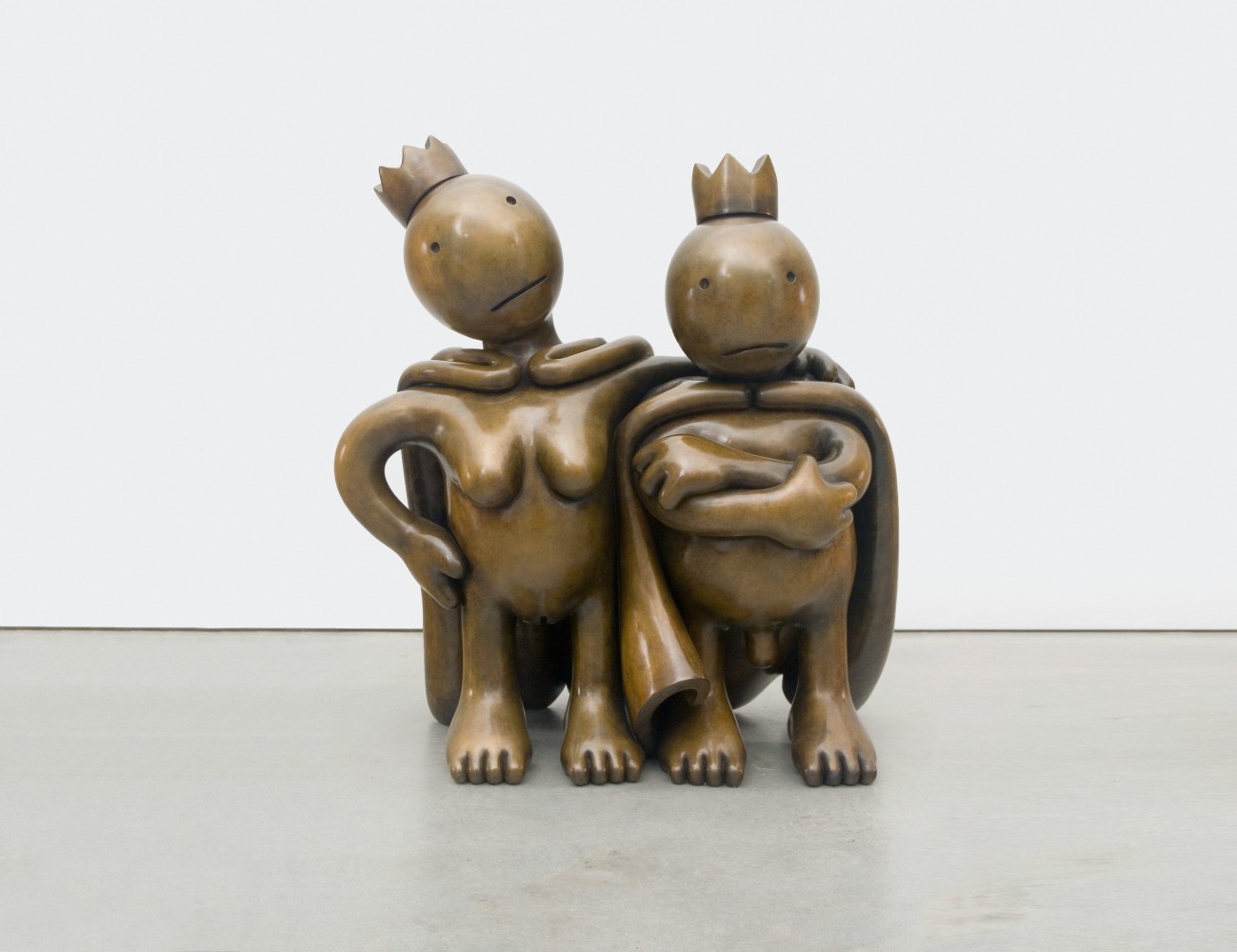 Two nude bronze figures with capes and crowns by Tom Otterness.