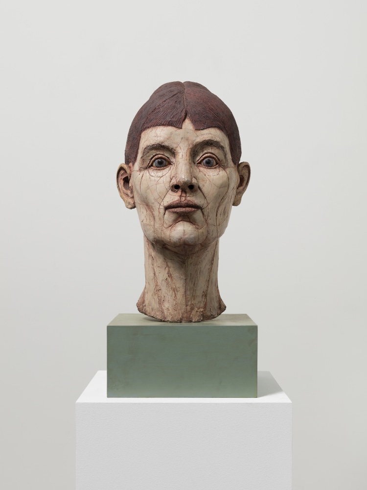 Resin, fiberglass, stone dust and acrylic sculptural head of figure with short brown hair and blue eyes