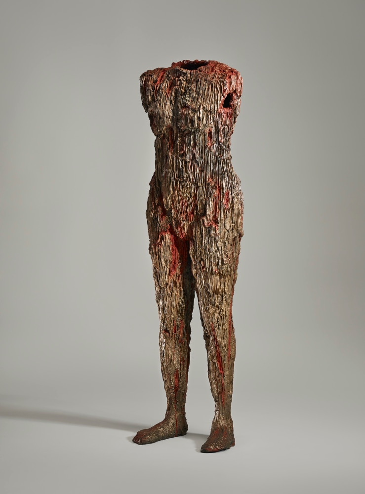 Cast bronze sculpture resembling human body with red and gold hues by Michele Oka Doner.