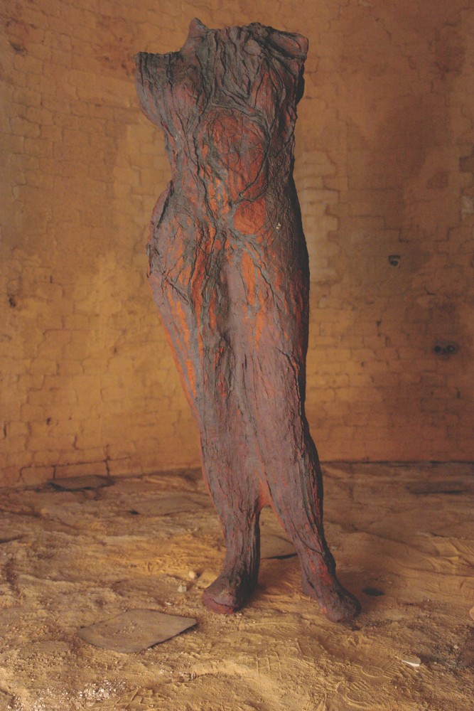 Textured earthenware sculpture of human body with burnt orange hues by Michele Oka Doner.