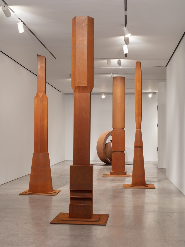 Photo of four large-scale steel columns installed inside a gallery