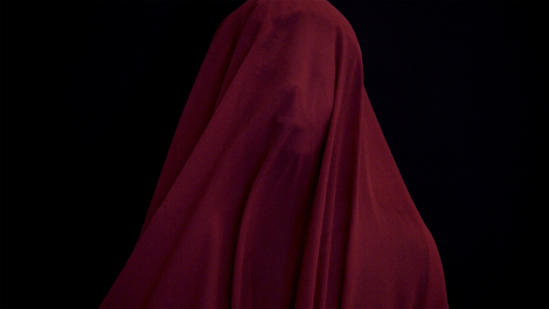 Digital print of a figure covered in a red sheet against a black background