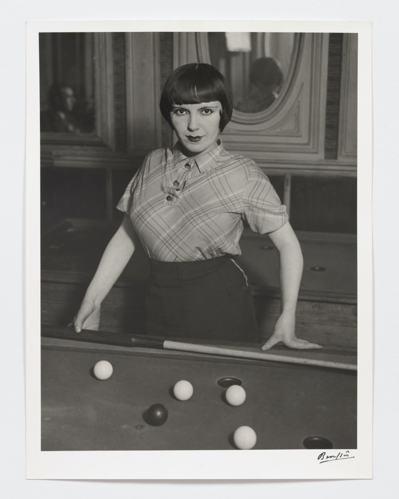 Black and white photographic portrait of a prostitute playing Russian billiards.