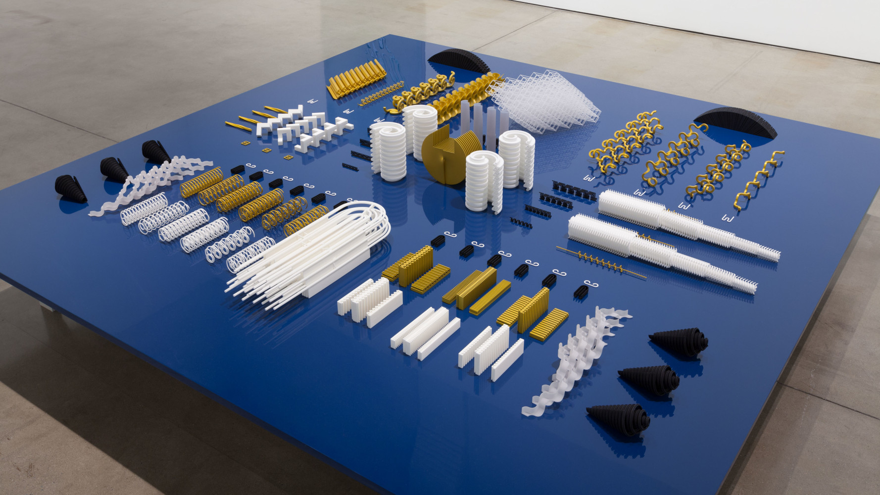 Tauba Auerbach Altar/Engine, 2015 3D printed nylon and plastic on table of aluminum, wood and paint an array of 126 elements ranging from 18 x 18 x 10 in. (45.7 x 45.7x 25.4 cm) to .0625 x 1 x 2 in. (.16 x 2.5 x 5.1 cm) Table: 15 x 108 x 108 in. (38.1 x 274.3 x 274.3 cm)