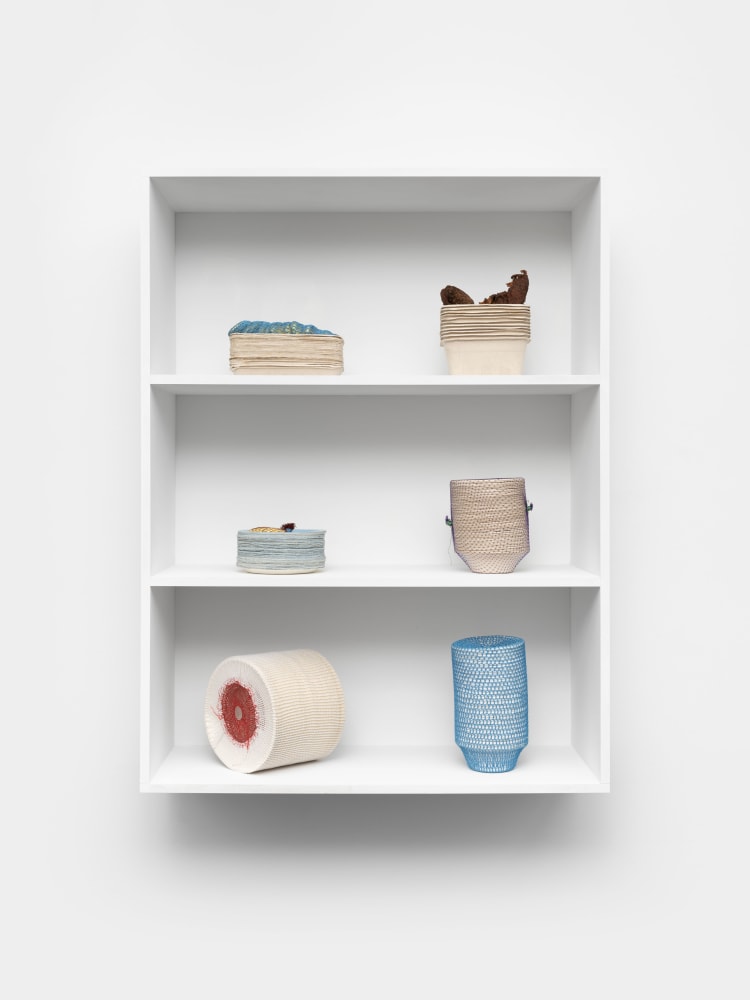 Veronica Ryan Holding Stacks, 2021 card containers, seed husks, cotton crochet, paper plates, avocado trays, hydrocal, plastic net, hairnet, fishing line, cotton, mango stones