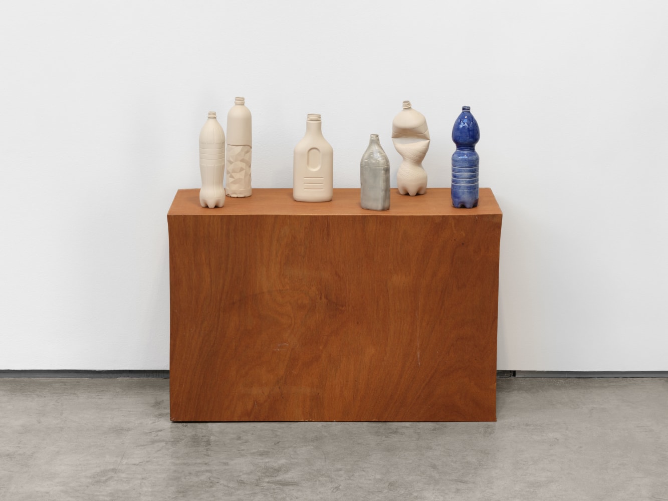 Veronica Ryan Still Life (Bottles), 2025 stoneware, blue glaze, wooden base bottles: 12 x 11 x 31 in. (30.5 x 27.9 x 78.7 cm) structure: 24 1/4 x 16 1/4 x 37 3/16 in. (61.6 x 41.3 x 94.5 cm)