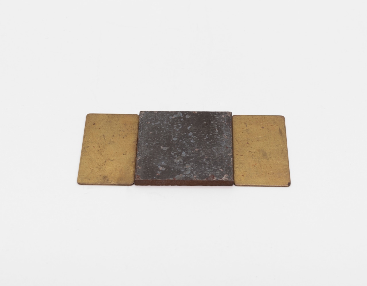 Carl Andre Brass and Steel Triplet, 2014 brass and steel brass: 1/32 x 1 1/2 x 7/8 in. (.1 x 3.8 x 2.2 cm) steel: 1/8 x 1 1/2 x 1 1/2 in. (.3 x 3.8 x 3.8 cm) overall: 1/8 x 3 1/4 x 1 1/2 in. (.3 x 8.3 x 3.8 cm)
