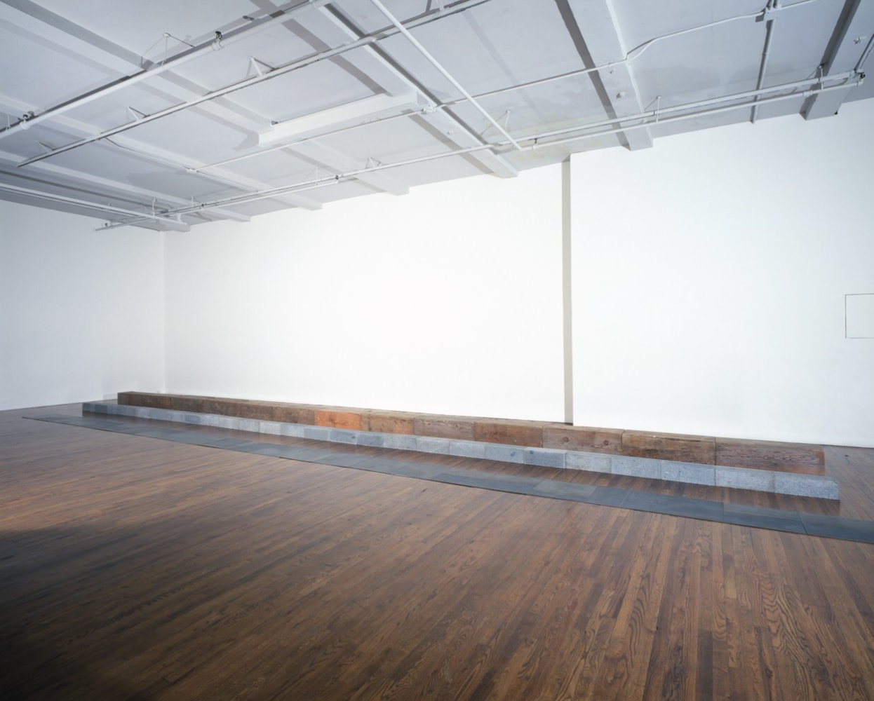 Carl Andre &quot;Paraglyph&quot; 1989 Steel plates, 24 units; Quincy granite, 26 units; Eastern pine, 13 units steel: 1/4&quot; x 38' 5 3/4&quot; x 19 5/9&quot; overall granite: 6&quot; x 39' 1/2&quot; x 12&quot; timber: 12&quot; x 39' 1/2&quot; x 12&quot; overall