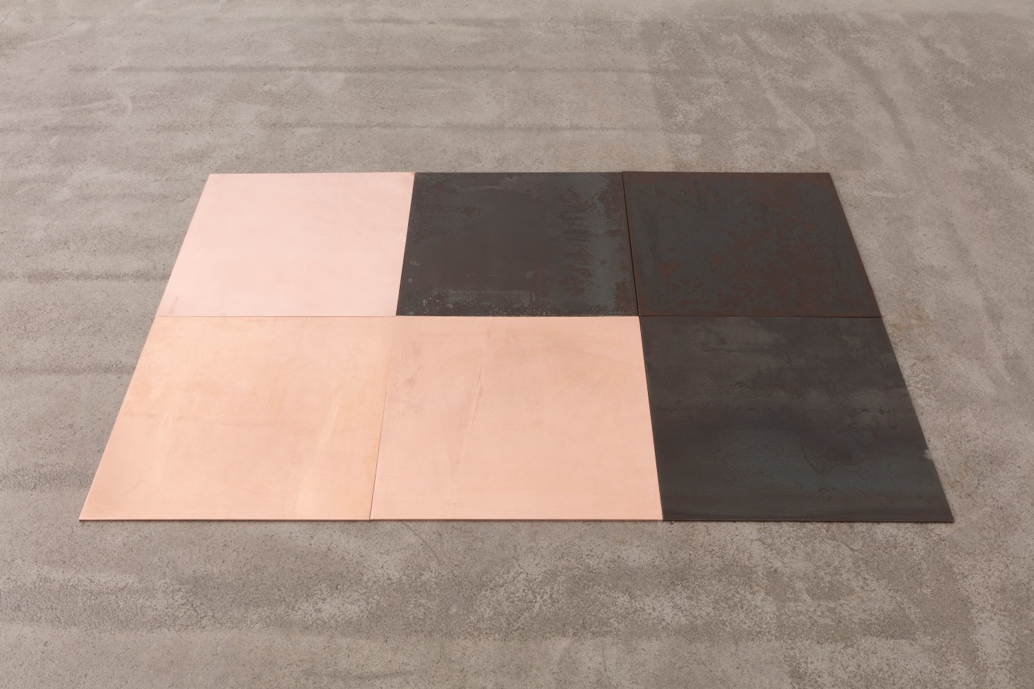 Carl Andre
CuFe Triplets, 2018
3 copper plates, 3 steel plates
6-unit (2 x 3) rectangle on floor; one steel right-angle triangle interlocking with one copper right-angle triangle
each unit: 3/16 x 19 11/16 x 19 11/16 in. (.5 x 50 x 50 cm)
overall: 3/16 x 59 1/16 x 39 3/8 in. (.5 x 150 x 100 cm)