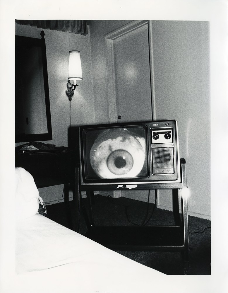 Bruce Conner's THE LATE NIGHT MOVIE ON TV 11A: JUNE 10, 1978, a gelatin silver print depicting a TV monitor in interior with an eye on screen