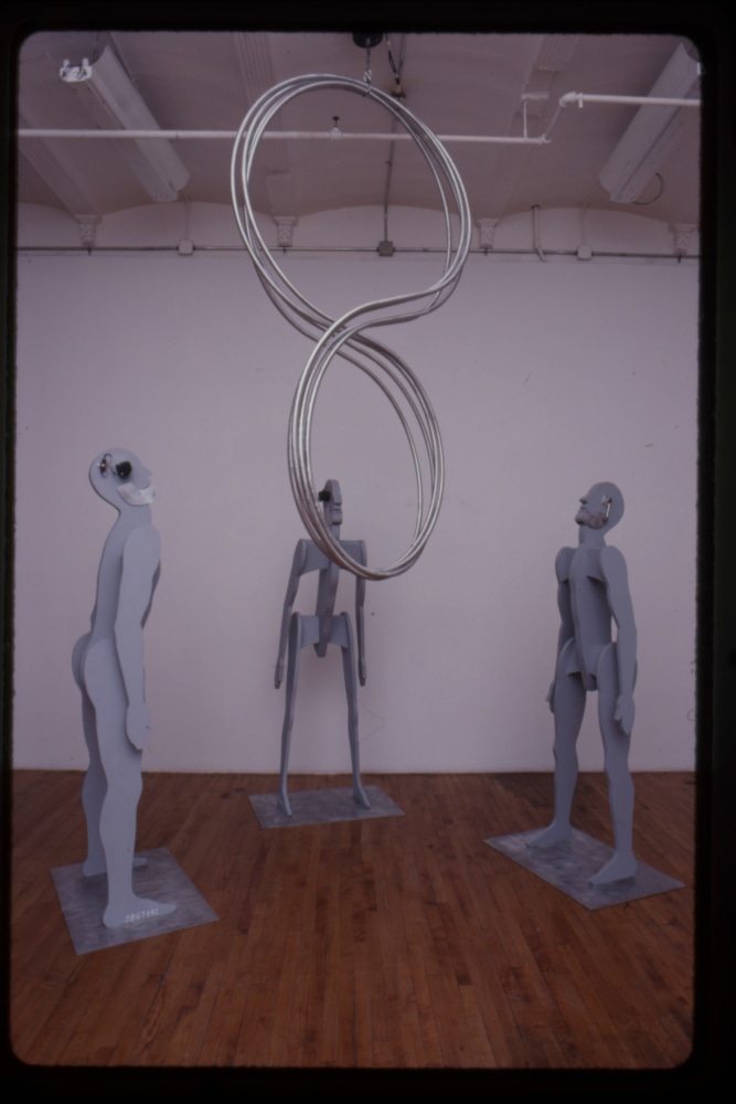 Jonathan Borofsky &quot;Spinning Figure 8 with Chattering Man&quot; 1986 Aluminum tubing, motor, cable Men: aluminum, wood, primer, Bondo, electric motor, speaker Figure 8: 96 x 48&quot; Each man: 82 1/2&quot; x 24 x 13&quot;