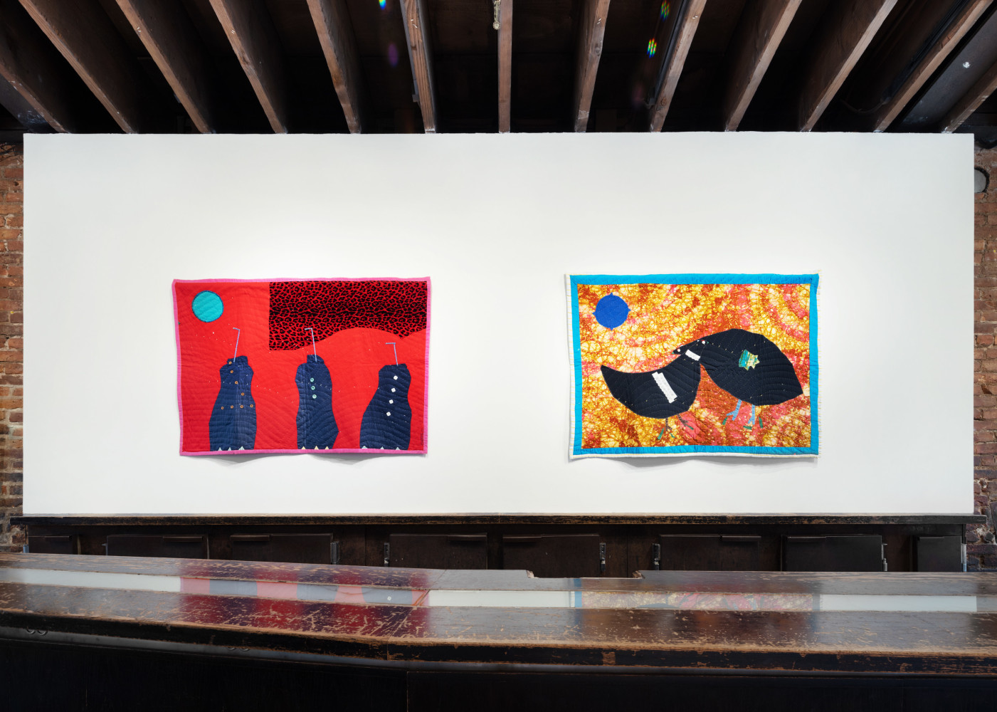 An image of two quilts installed in the lobby of the gallery